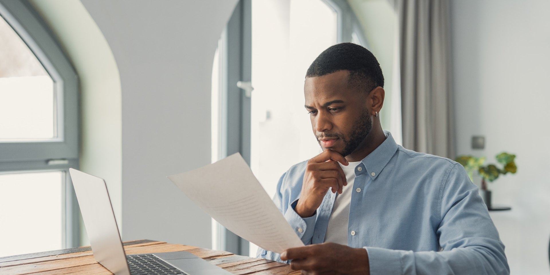 Man reading a printed CV at a desk