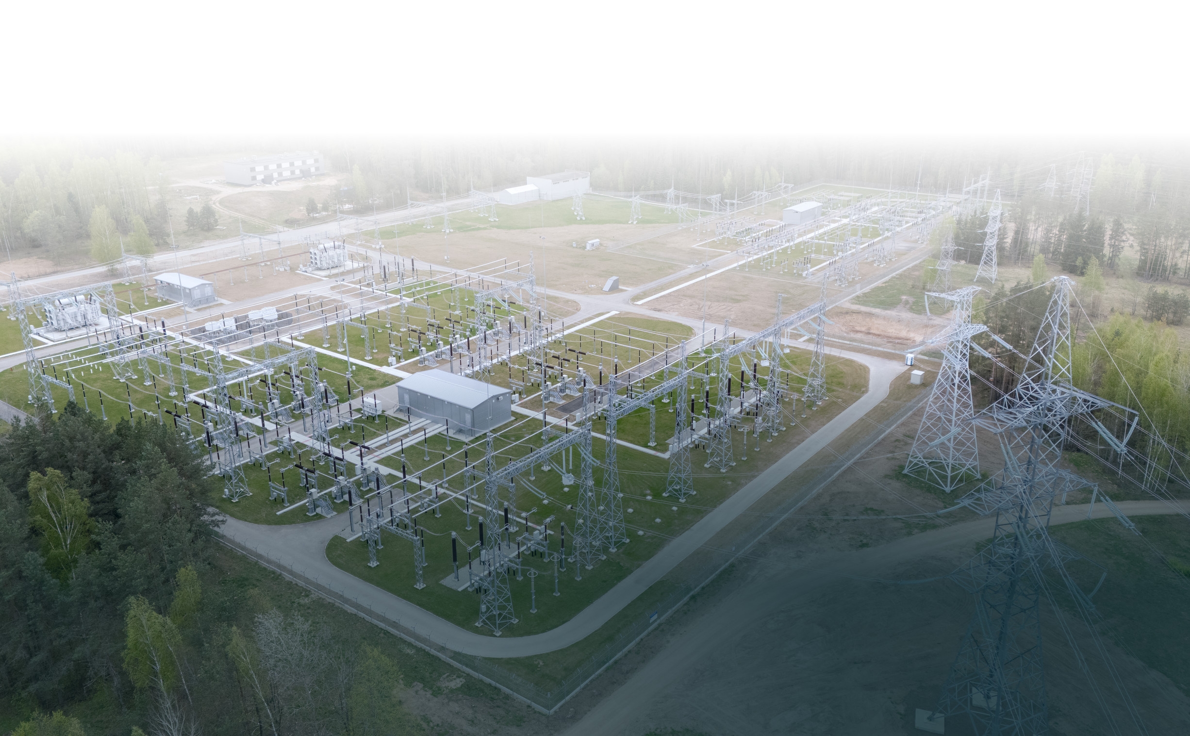 Aerial view of a high-voltage substation with transmission pylons